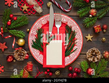 Table festive avec ornements, branches en sapin et carte vierge vue du dessus.Maquette de Noël ou du nouvel an carte de placement sur table en bois sombre Banque D'Images