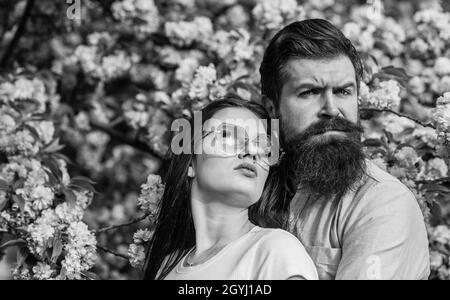 Fleurs roses de cerisier.Homme et femme amoureux.Couple aimant sous les branches fleuris le jour du printemps.Couple appréciant un moment dans le jardin fleuri Banque D'Images