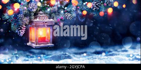 Lanterne de Noël dans la nuit avec neige et branche de sapin Banque D'Images