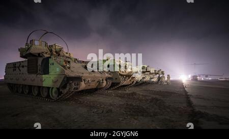 L'ARMÉE AMÉRICAINE M2 et véhicules de combat Bradley M1A1 Abrams tanks sont garés à côté d'une ligne de vol dans la zone de responsabilité, le 3 janvier 2020. L'USCENTCOM dirige et permet aux opérations et activités militaires avec les alliés et partenaires afin d'accroître la sécurité et la stabilité régionale à l'appui durable d'intérêts américains. (U.S. Air Force photo de Tech. Le Sgt. Daniel Martinez) Banque D'Images