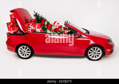 Photo de positif drôle excités personnes santa équipe conduite voiture livrer présente porter costume isolé couleur blanc arrière-plan Banque D'Images