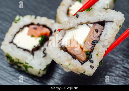 Gros plan sur le saumon fumé, le fromage doux et le rouleau de ciboulette californien, cuisine japonaise traditionnelle Banque D'Images