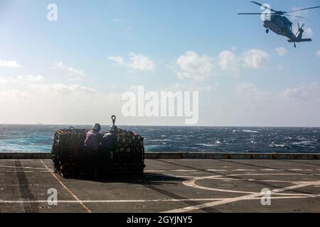 200108-N-GR168-1256 MER MÉDITERRANÉE (JANV8, 2020) Aviation Boatswain’s Mate (Handling) Airman Shamus Fraser, à droite, et Aviation Boatswain’s Mate (Fuels) Airman Fernando Guevara, tous deux affectés au quai de transport amphibie de classe San Antonio USS New York (LPD 21), se préparent à accrocher des cargaisons à un hélicoptère MH-Hawk Sea 60S,Affecté au Dragon Whales of Helicopter Sea combat Squadron (HSC) 28, sur le pont de vol de New York lors d'un réapprovisionnement en mer, le 8 janvier 2020.New York, qui a son siège à Mayport, en Floride, mène des opérations navales dans la zone d'opérations de la 6e flotte américaine Banque D'Images