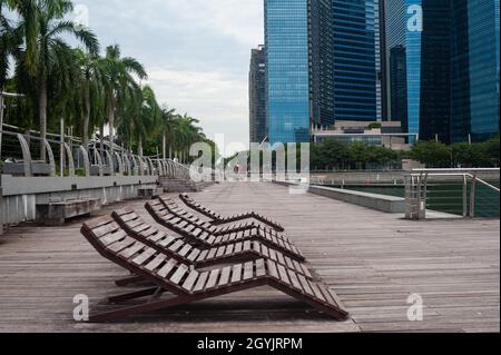 07.10.2021, Singapour, République de Singapour, Asie - chaises longues libérées le long de la promenade de bord de mer à Marina Bay pendant la crise corona durable. Banque D'Images