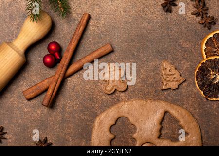 Pâte de pain d'épice, un biscuit d'homme de pain d'épice, un biscuit d'arbre de Noël, un rollpin, des épices, des ornements d'arbre de Noël rouge.Les fêtes sont à venir. Banque D'Images