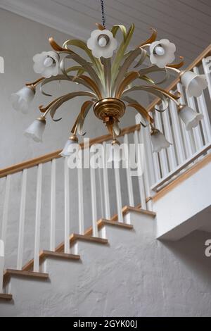 Magnifique lustre lumineux fleuri au-dessus d'un escalier en bois de garde-corps Banque D'Images