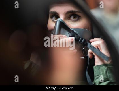 Un aviateur du 1er Escadron de soutien opérationnel AirCrew Flight Equipment tient un miroir pour la journaliste locale Madeline Schmitt, pour vérifier que le masque à oxygène est bien adapté pour un vol médiatique à venir dans un avion T-38A talon à la base conjointe Langley-Eustis, le 15 janvier 2020.Ce vol démontre les rigueurs d'entraînement que les pilotes de l'US Air Force peuvent supporter pendant les opérations de vol.La 1re Escadre de chasseurs a commencé à intégrer des physiothérapeutes du 633e Escadron des opérations médicales en 2019 pour s'attaquer aux douleurs au cou et au dos auxquelles les équipages d'avions de combat endurent afin de gagner du temps et de fournir des soins de santé préventifs. Banque D'Images