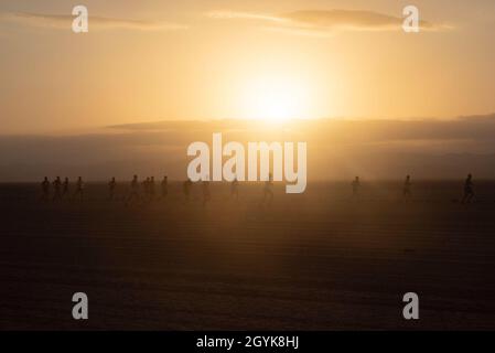 Les participants de la course Grand Bara courent alors que le soleil se lève sur le Grand Bara Desert, Djibouti, le 15 janvier 2020.Environ 200 participants affectés à la Force opérationnelle conjointe de la Corne de l'Afrique et au Camp Lemonnier ont participé à des compétitions avec des partenaires de la coalition et des civils de Djibouti, de France, d'Espagne, d'Italie et d'Allemagne.(É.-U.Photo de la Force aérienne par Tech.Sgt.Ashley Nicole Taylor) Banque D'Images