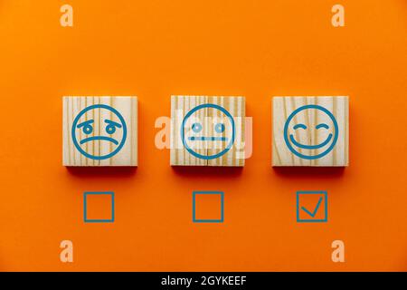 Fond orange avec tuiles d'émotions et cases à cocher pour les enquêtes de satisfaction client Banque D'Images