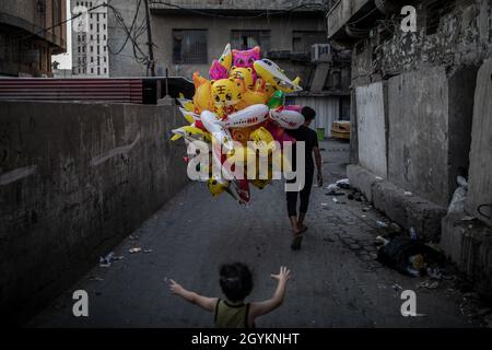 Bagdad, Irak.08 octobre 2021.Un enfant réagit alors qu'un vendeur de ballons se promène dans une rue du vieux quartier de Bagdad.Les Irakiens devraient voter lors d'élections législatives anticipées qui auront lieu le 10 octobre.Credit: Oliver Weiken/dpa/Alay Live News Banque D'Images