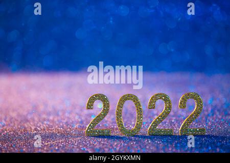 Célébration du nouvel an 2022 - numéros d'or sur fond bleu et bokeh Banque D'Images