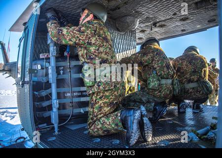 Les soldats de la Force d'autodéfense au sol du Japon, avec la 5e Brigade, assemblent le système de retenue des victimes à l'arrière d'un hélicoptère utilitaire Bell UH-1 Iroquois pendant l'exercice Viper du Nord sur la zone d'entraînement de Yusubetsu, Hokkaido (Japon), le 26 janvier 2020.Personnel actuellement affecté à l'élément de combat logistique pour l'exercice Northern Viper train dans les environnements austères pour préparer les unités pour toutes les conditions météorologiques.Northern Viper est un exercice de formation régulier conçu pour améliorer l'interopérabilité de l'Alliance américaine et japonaise en permettant aux forces de travail aériennes-terrestres de Marine de III mari Banque D'Images