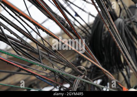 Fils électriques et de signal désordonnés sur un poste en ville, désordonné de fils électriques et de la ligne de signal de fibre d'Internet sur des pôles électriques. Banque D'Images