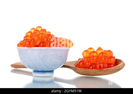 Caviar de saumon kéta rouge légèrement salé avec une cuillère en bois et une soucoupe en céramique, en gros plan, isolée sur du blanc. Banque D'Images