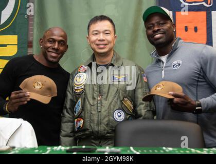 GRANDS LACS, il.(Janv29, 2020) le capitaine Ray Leung (au centre), commandant de la base navale des Grands Lacs, de Phoenix, en Arizona, pose avec Donald Driver, ancien joueur des Green Bay Packers,Et Alex Brown, ancien joueur des Chicago Cubs, après leur présentation avec des casquettes de commande lors d'un repas Super Bowl à Galley 535 à la base navale de Great Lakes.L'événement, organisé par le moral, le bien-être et les loisirs des Grands Lacs (MWR), a eu la nourriture sur le thème du hayon, une rencontre et un accueil avec les joueurs, et une tombola pour les marins.(É.-U.Photo de la marine par Brigitte John, Spécialiste des communications de masse, 2e classe Banque D'Images