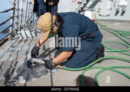 OCÉAN PACIFIQUE (janv29, 2020) la Matelot de 1re classe Kristina Montano, de Los Angeles, grine le pont du destroyer guidé de la classe Arleigh Burke USS Kidd (DDG 100) le 29 janvier 2020.Kidd, qui fait partie du groupe de grève des transporteurs Theodore Roosevelt, est en cours de déploiement dans l'Indo-Pacifique.(É.-U.Navy photo par Mass communication Specialist 3rd Class Brandie Nuzzi) Banque D'Images