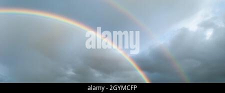 Double arc-en-ciel dans un ciel orageux dans la soirée.France, Europe. Banque D'Images