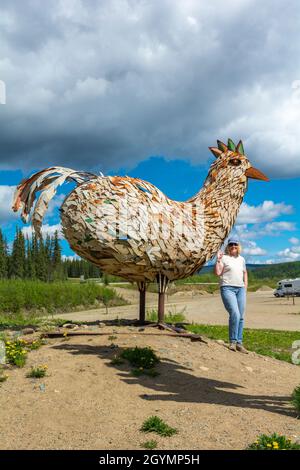 États-Unis, Alaska, poulet, sculpture métallique, visiteur féminin Banque D'Images