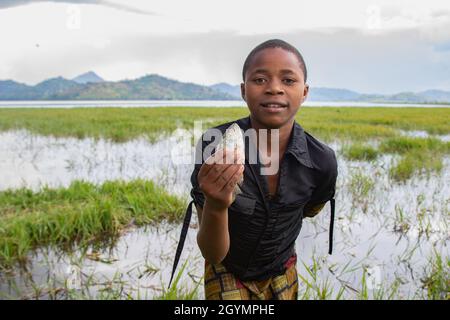 Portrait d'un garçon qui vient de pêcher un poisson.Rwanda. Banque D'Images