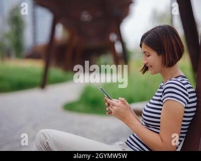 belle jeune femme asiatique passant du temps dans un parc urbain contemporain le jour de l'été. Banque D'Images