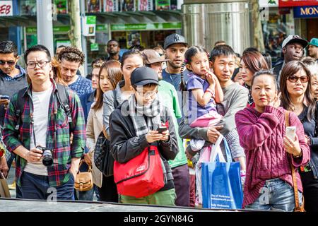 Melbourne Australie, Swanston Street, asiatique mère fille fille père tenant des parents de famille enfants piétons, passage à niveau bondé Banque D'Images