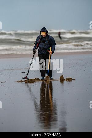 Chasseur de trésors, homme avec détecteur de métaux sur la plage, nuages de tempête sombre, automne à la mer du Nord en Hollande du Nord, près du village Egmond aan Zee, N Banque D'Images