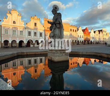 Vue en soirée sur la place de Telc ou de Teltsch, bâtiment reflétant la fontaine publique avec statue de St. Margaret, république tchèque. Site du patrimoine mondial par Banque D'Images