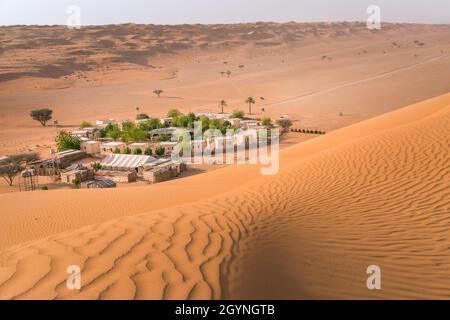 Petit camp avec arbres au milieu du désert arabe.Oasis à Wahiba Sands, Oman.Journée chaude dans les dunes de la péninsule arabe. Banque D'Images