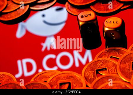 JD.com est une société chinoise de commerce électronique.Dés avec les mots VENDRE ACHETER.JD.com logo entouré de pièces de monnaie feng shui. Banque D'Images