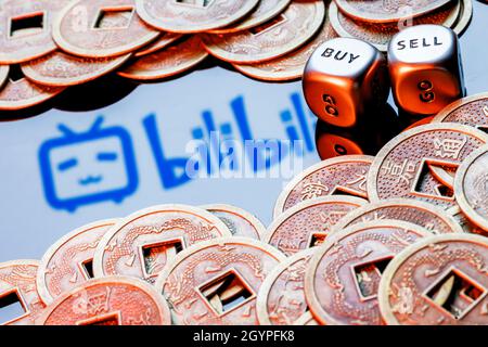 Dés avec les mots VENDRE ACHETER.Logo Bilibili entouré de pièces de monnaie feng shui. Banque D'Images