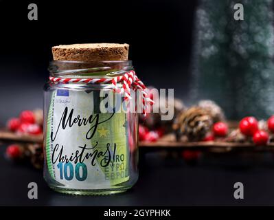 Euro argent billet dans pot de noël avec texte joyeux noël sur fond noir avec décoration de noël Banque D'Images
