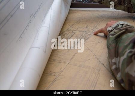 Sergent d'état-majorAaron Williams, chef d’équipe pour le bureau de géo-intégration de la station d’armement du 628e Escadron de génie civil, examine le détail d’un plan d’un bâtiment à la joint base Charleston S.C., janvier 22,2020 le bureau de géo-intégration soutient la mission en conservant et en maintenant ces dossiers de tous les plans de structure de base communs afin que les ingénieurs puissent recréer ou améliorer les défauts dans les structures, ce qui permet l'innovation à la base Banque D'Images