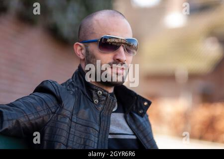 Portrait d'un bel homme barbu de Pologne portant des lunettes de soleil et une veste en cuir Banque D'Images
