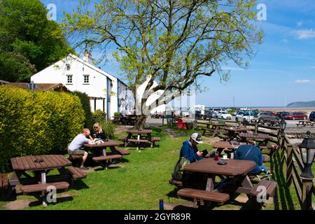 Anglesey - pays de Galles - Mai 5 2016 : l'ancien et charmant Ship Inn à Red Wharf Bay vue sur le café en plein air avec des vacanciers assis au soleil de Landsca Banque D'Images