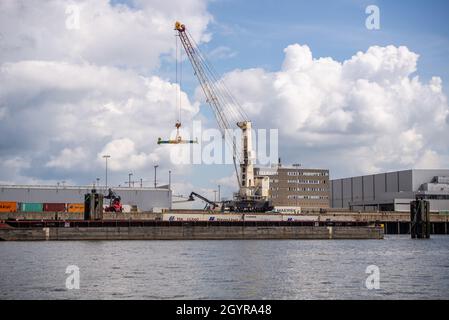 Hambourg, Allemagne-août 11,2021 : une grue décharge les conteneurs d'expédition d'une barge. Banque D'Images