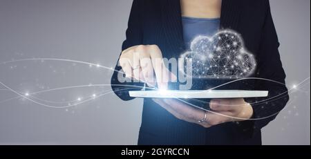 Concept Internet de la technologie de Cloud Computing.Tablette blanche en main femme d'affaires avec logo numérique de nuage numérique sur fond gris.Communica Banque D'Images