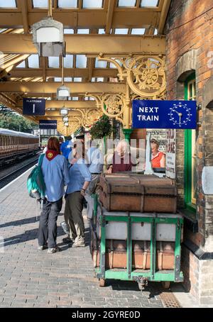 Sheringham, Norfolk, Royaume-Uni - SEPTEMBRE 14 2019 : personnes sur une plate-forme de train d'époque avec des valises d'époque pendant le week-end des années 1940 Banque D'Images