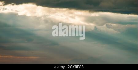 Les rayons du soleil se brisent à travers des nuages sombres suggestifs.Pas de vue sur la terre. Banque D'Images