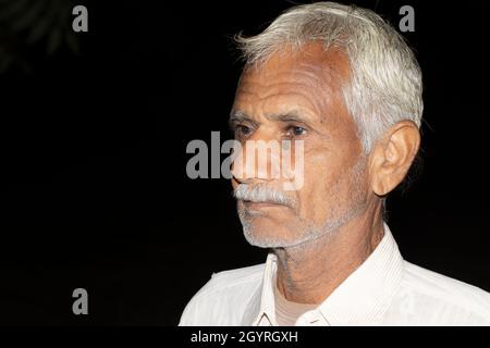 Photo en gros plan d'un Indien à la retraite et de citoyens âgés heureux avec un arrière-plan noir isolé de faible clé, l'inde Banque D'Images