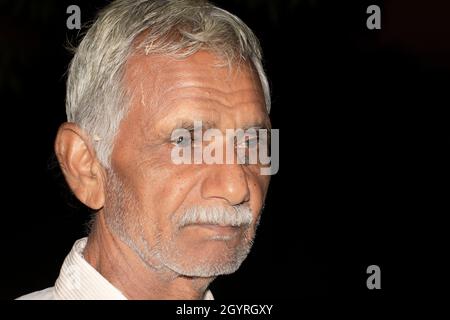 Photo en gros plan d'un homme à la retraite ou de citoyens indiens âgés en bonne santé avec un arrière-plan noir isolé de faible clé, l'inde Banque D'Images