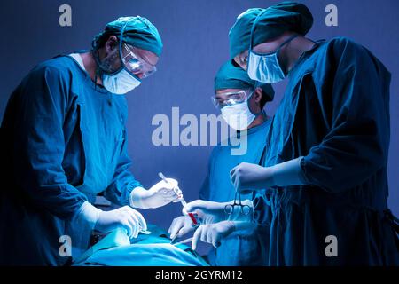 groupe de médecins chirurgicaux professionnels concentré chirurgie chirurgicale un patient dans la salle d'opération de l'hôpital. concept médical et de soins de santé. Banque D'Images