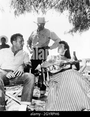 JANE RUSSELL assis avec son mari ROBERT / BOB WATERFIELD sur le terrain de jeu Candid à Durango Mexique avec le directeur RAOUL WALSH pendant le tournage des GRANDS HOMMES 1955 réalisateur RAOUL WALSH du roman de Heck Allen scénario Sydney Boehm et Frank S. Nugent musique Victor Young costumes Travilla vingtièmeRenard du siècle Banque D'Images