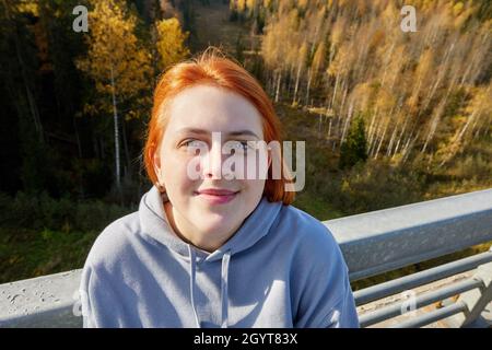 Portrait d'une jeune femme du caucase avec des cheveux rouges dans le parc. Banque D'Images