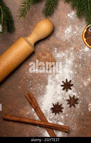 Gâteries de vacances.Le plan de travail de la cuisine est arrosé de farine.Un biscuit d'homme de pain d'épice est couché sur la surface de travail à côté d'une broche roulante et d'épices. Banque D'Images