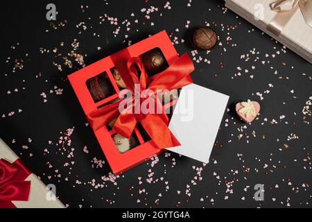 Bonbons à la truffe au chocolat faits main dans une boîte rouge sur fond sombre.Directement au-dessus de la vue de dessus. Banque D'Images