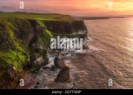 Belles falaises de calcaire blanc vues depuis le point de vue de Magherovers au coucher du soleil spectaculaire, Bushmills, Irlande du Nord Banque D'Images