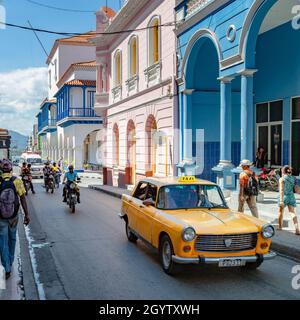 SANTIAGO DE CUBA, CUBA - 28 avril 2019 : une photo verticale d'un taxi jaune rétro conduisant dans une rue animée et magnifique de Santiago de Cuba Banque D'Images