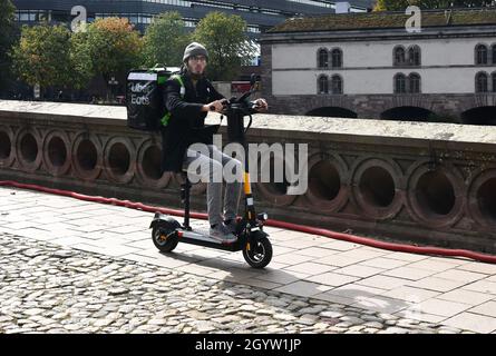 Uber mange des aliments en ligne commande et livraison par l'homme sur scooter électrique Strasbourg, France Banque D'Images