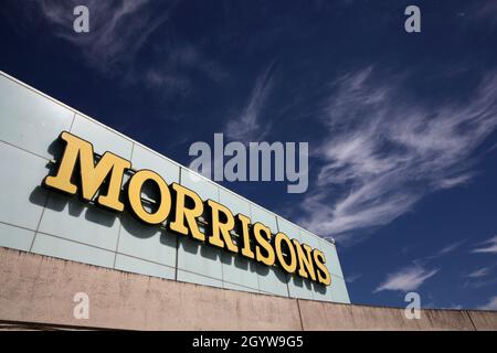 Le logo du supermarché Morrisons se trouve sur le côté du centre commercial Gyle d'Édimbourg, avec un ciel bleu et des nuages blancs moustaches en arrière-plan Banque D'Images