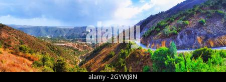 Panorama de la vallée de la montagne et traversée de la Lyell Highway au-dessus des chaînes en direction de Queenstown en Tasmanie, Australie. Banque D'Images